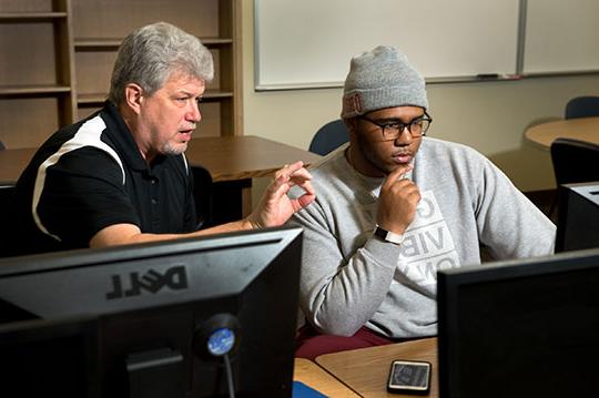 Blase Cindric with a student on a computer 